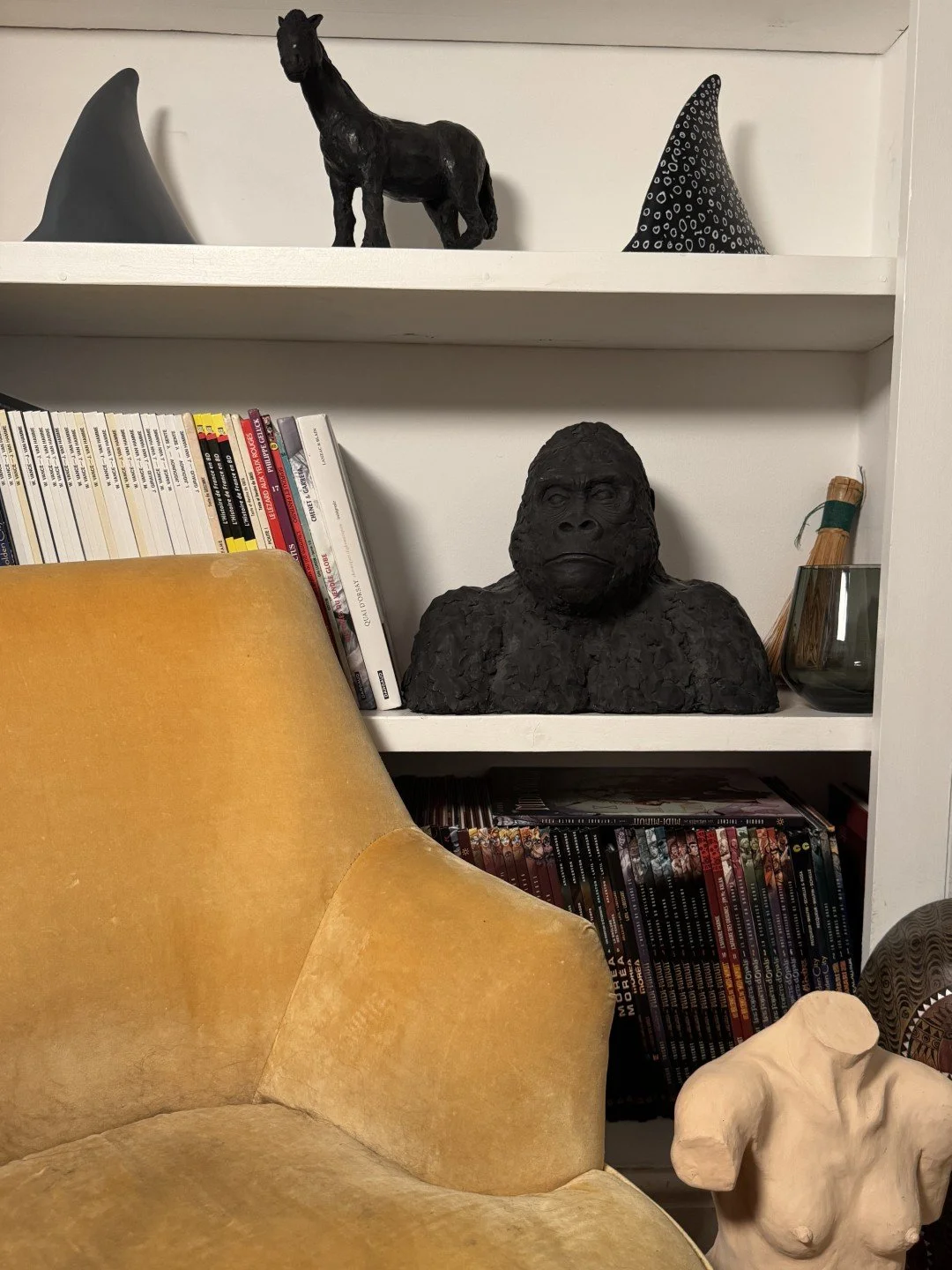 Gorilla Bust, a sculpture by Artist Julien Hipeau, cast in Jesmonite, displayed on shelves with other artworks.