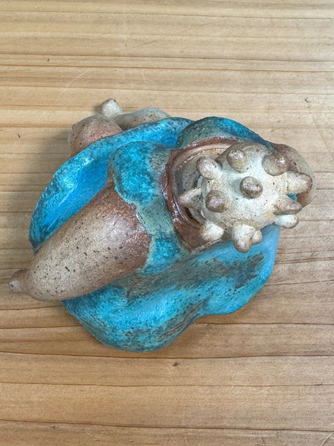 Top view of Sitting lady in a dress by ceramic Artist Nupur Narain DeTar, ahandmade sculpture inspired by African art.