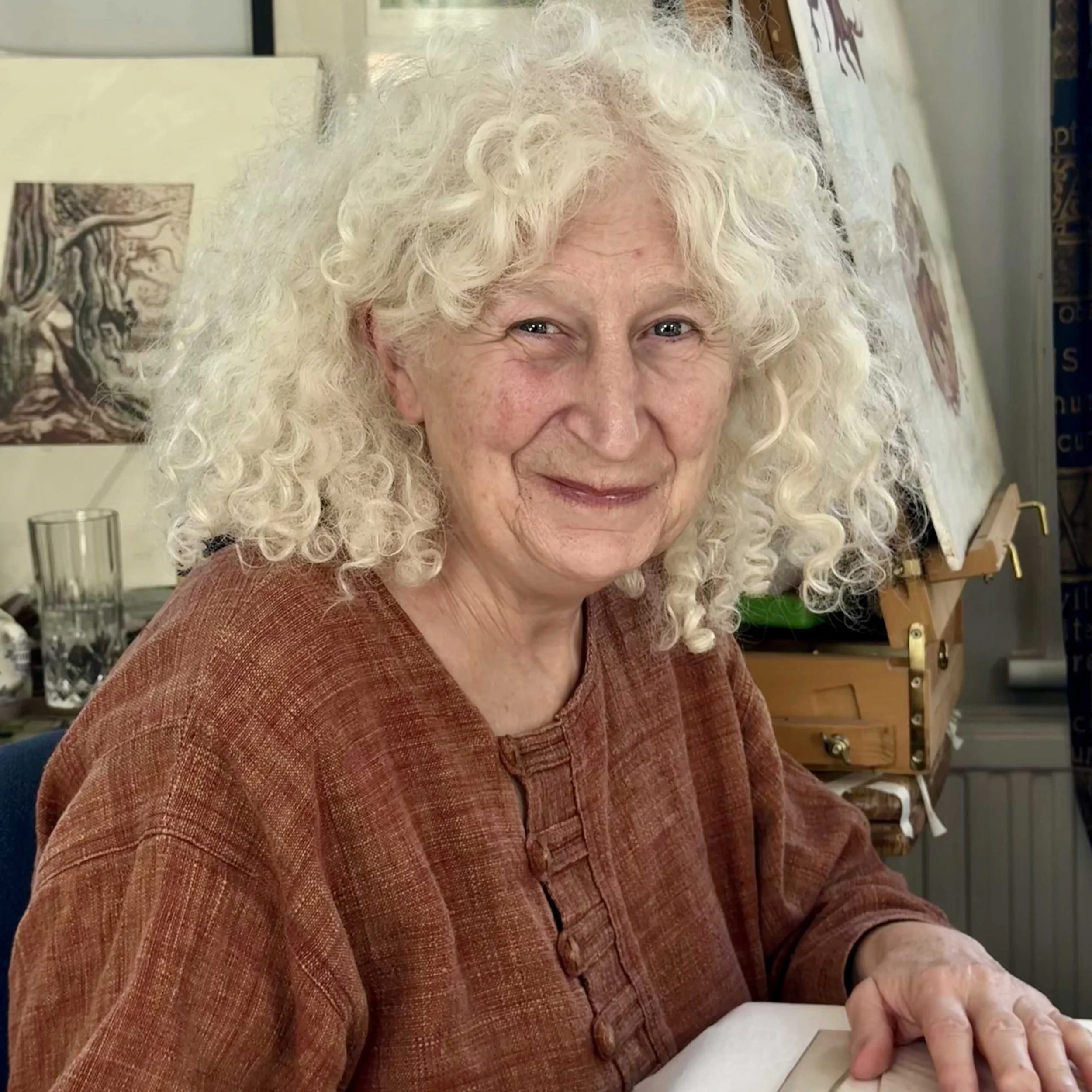 Portrait of Artist Noonie Minogue in her studio and surrounded by some of her prints..