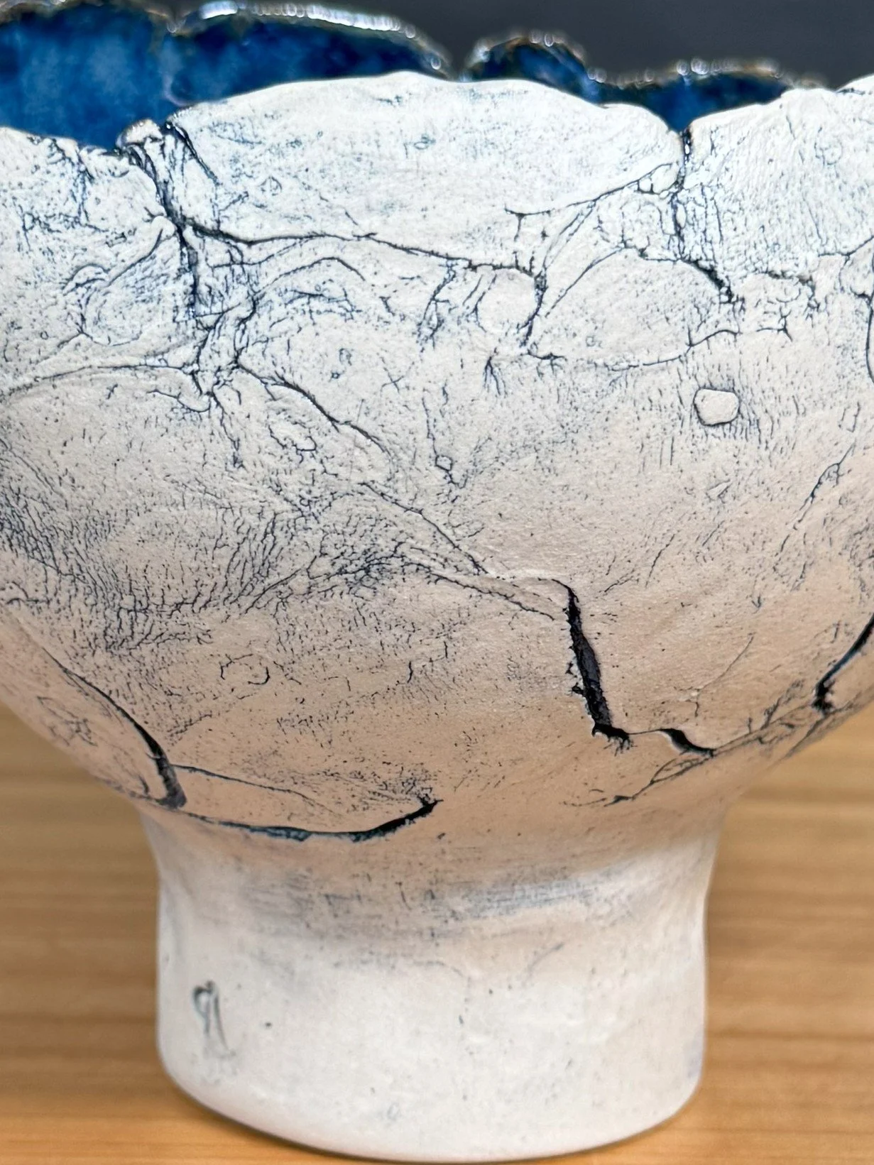 Closeup of handcrafted stoneware crackle bowl by Artist Nupur Narain DeTar, using blue pigments and a food-safe glaze inside.