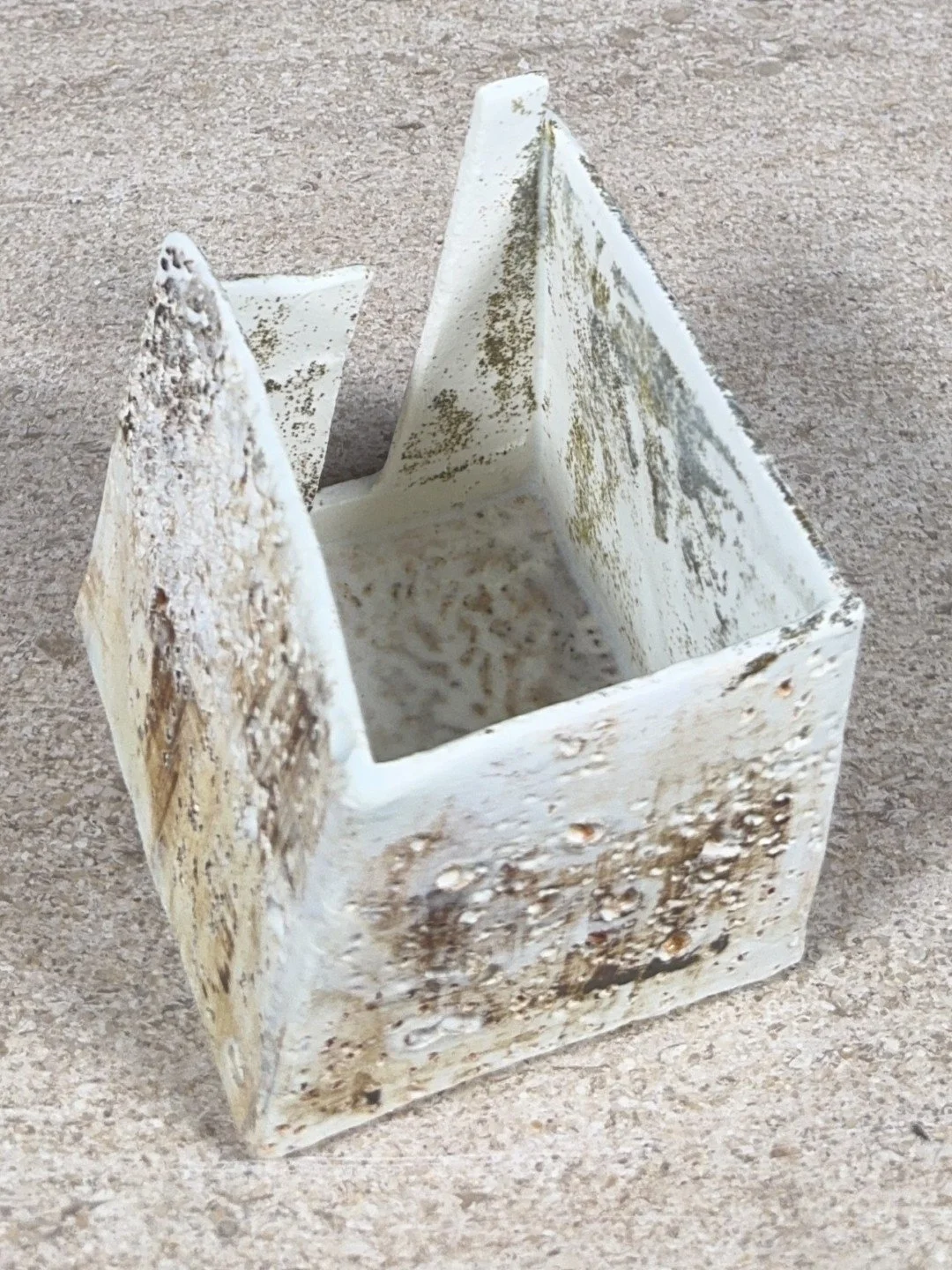 Patina on a building by ceramic Artist Cristina Lorenzet, white textured stoneware and porcelain sculpture, top back view.