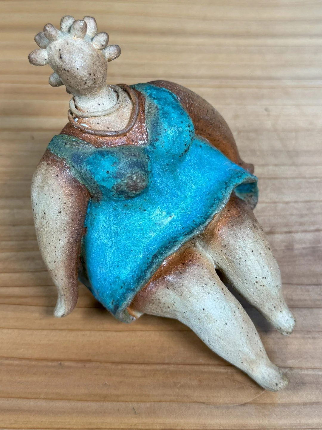 Top view of Sitting lady in a dress by Artist Nupur Narain DeTar, a beautiful handmade ceramic sculpture of the female form.