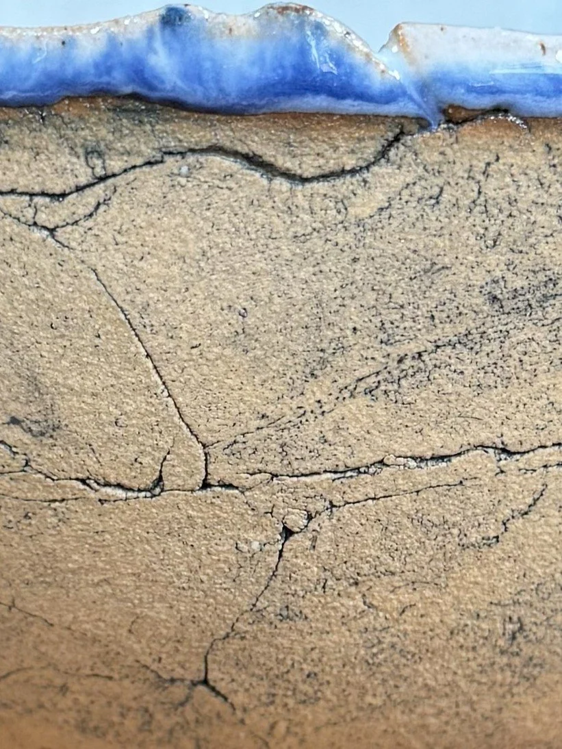 Closeup of large crackle bowl by Artist Nupur Narain DeTar, with food-safe copper blue glaze, blue rim and exposed exterior.