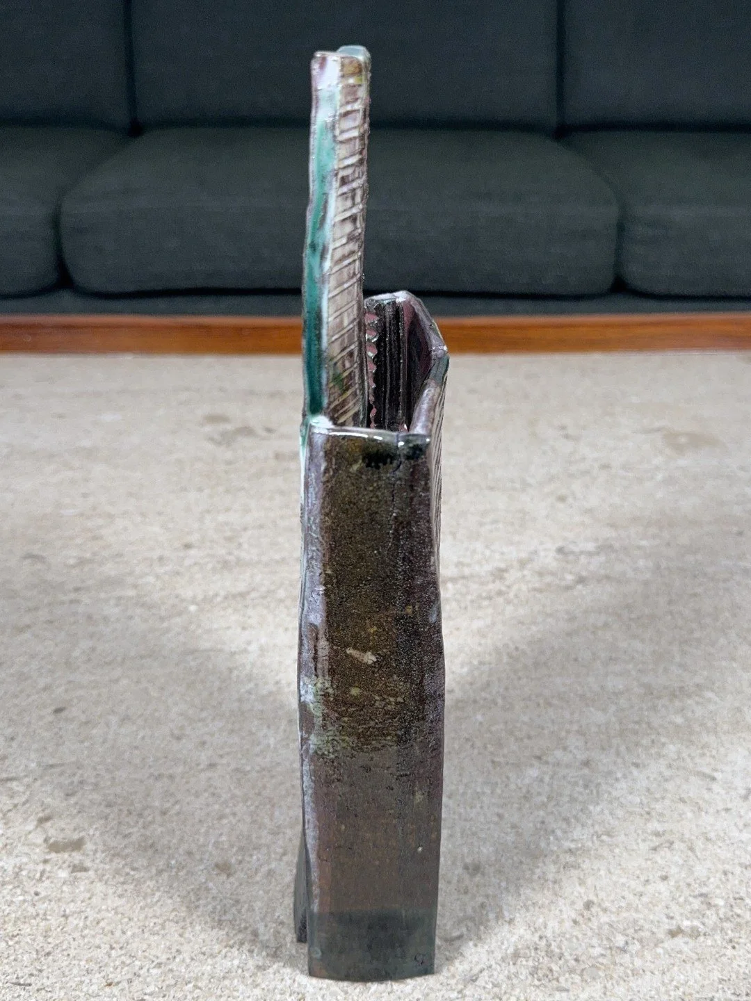 Side view of Skyline 4 by ceramic Artist Cristina Lorenzet, a red stoneware sculpture decorated with white and green slips.