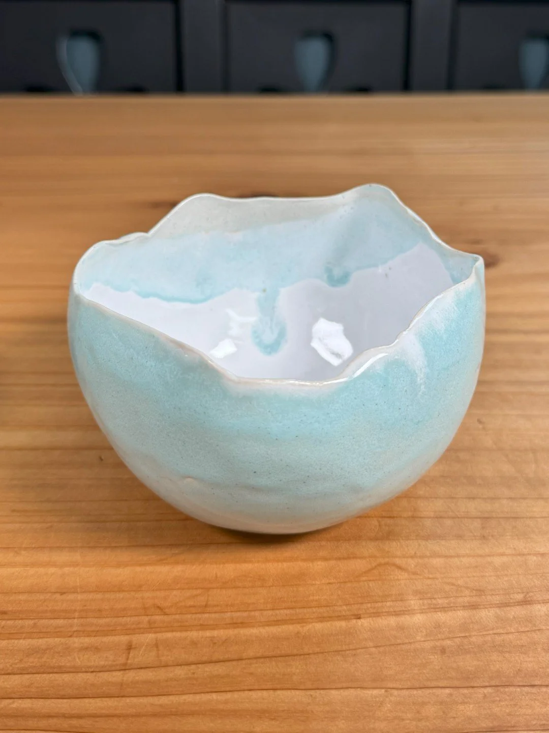 Medium raw-edged bowl by ceramic Artist Nupur Narain DeTar, hand-built with white glaze inside and copper blue outside.