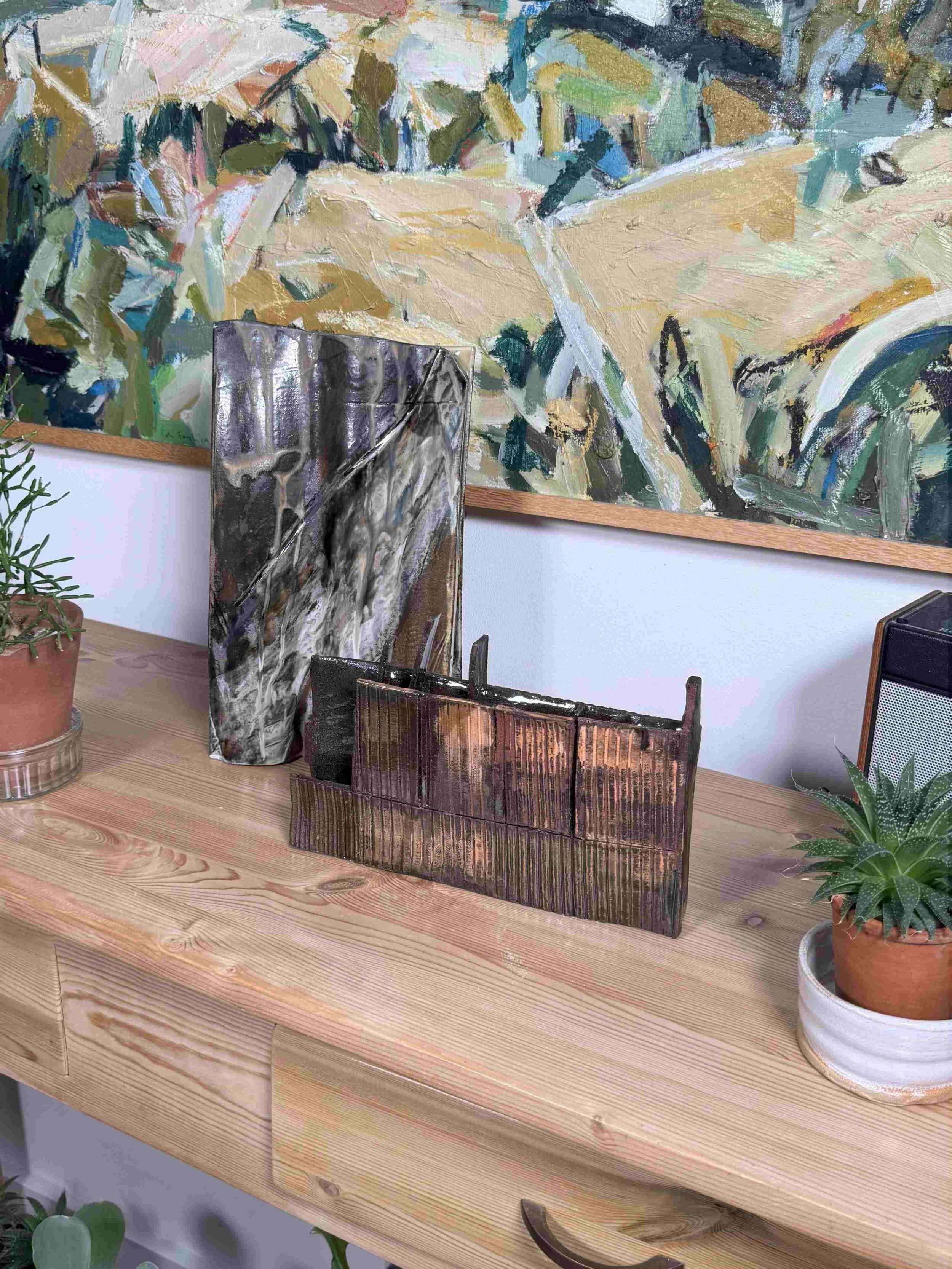 Skyline 1 red stoneware sculpture by ceramic Artist Cristina Lorenzet displayed on a side table with Rooftile artwork.