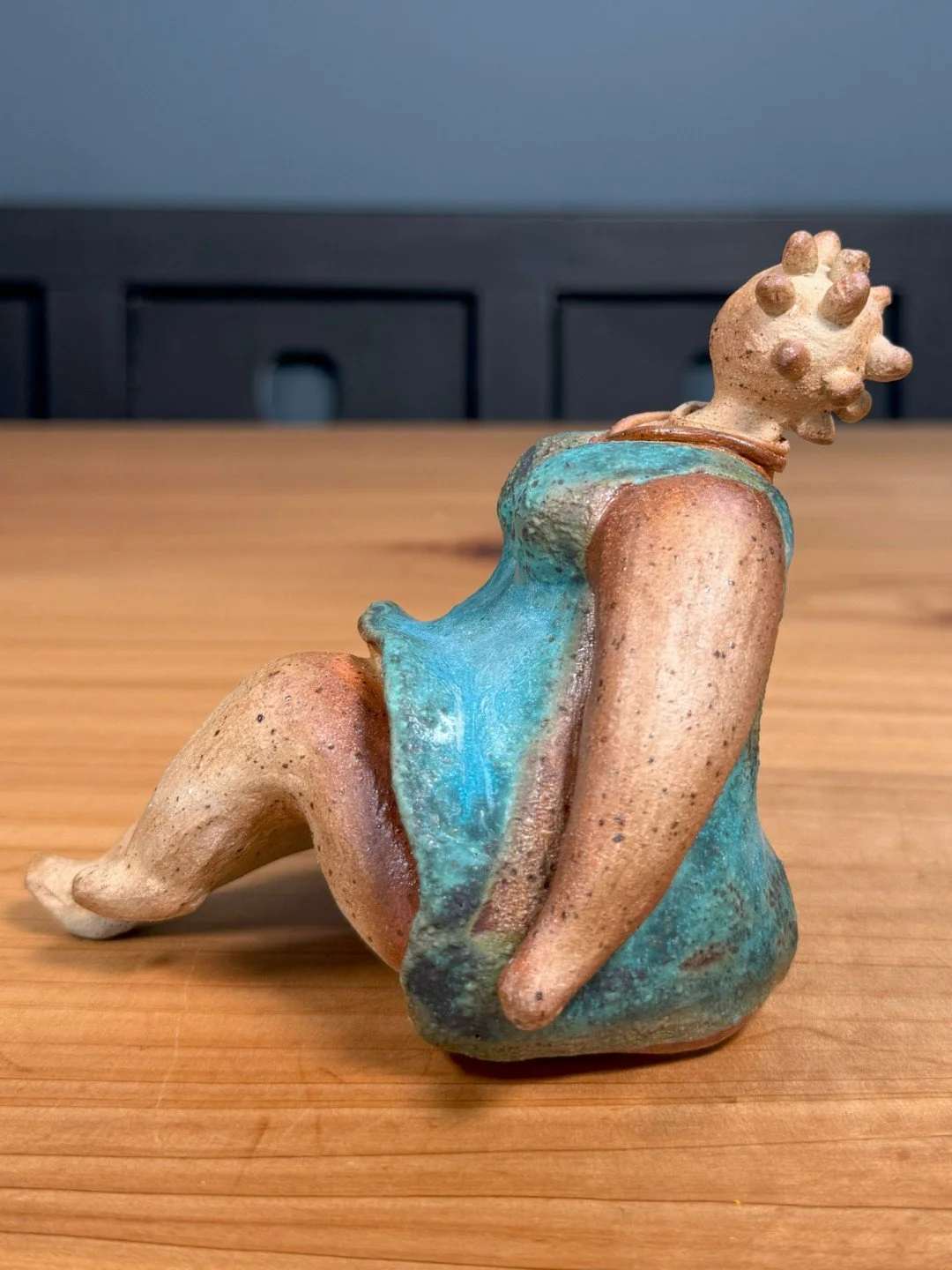 Side view of Sitting lady in a dress by Artist Nupur Narain DeTar, a beautiful handmade ceramic sculpture of the female form.
