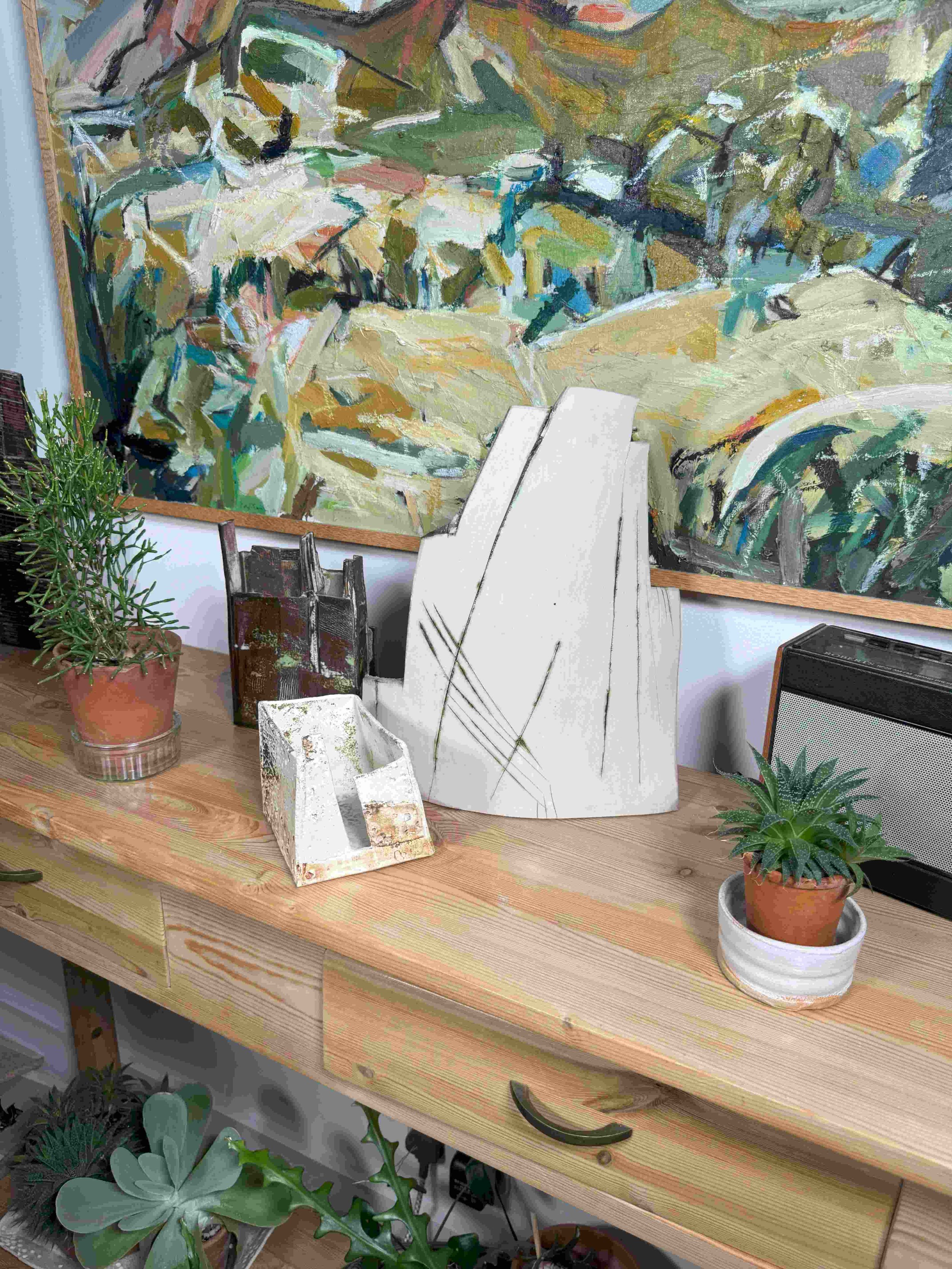 Red stoneware sculpture Skyline 2 by Artist Cristina Lorenzet displayed with other sculptures on a kitchen side table