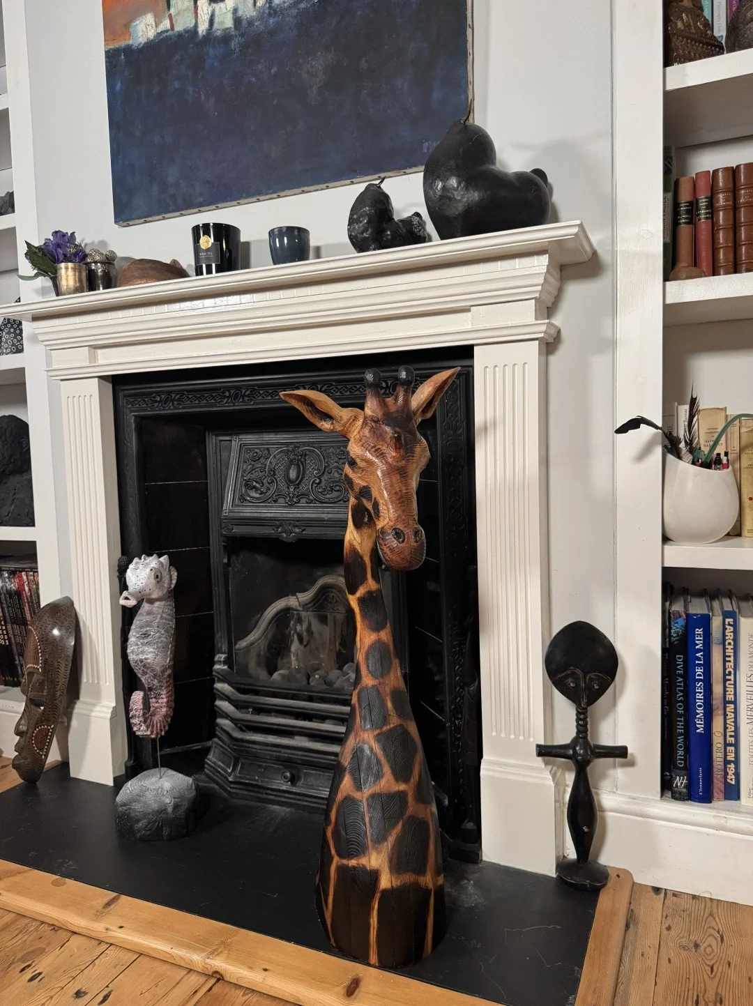 Seahorse sculpture by Artist Julien Hipeau, displayed with other artworks in front of a fireplace in a living room.