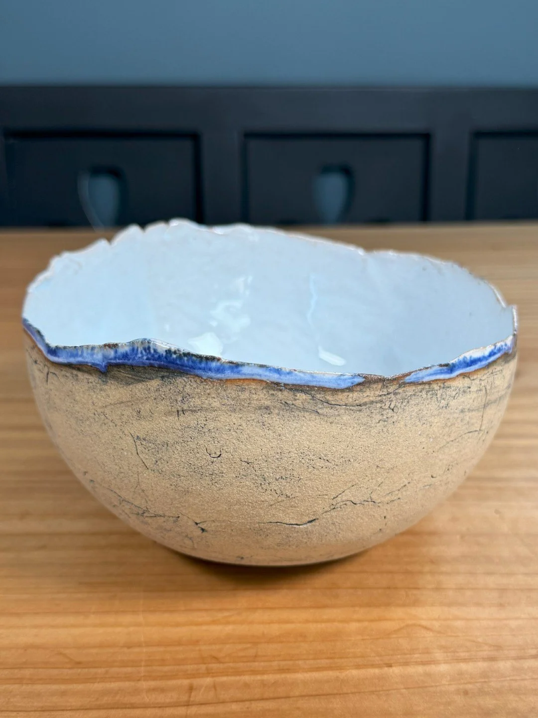 Large crackle bowl by ceramic Artist Nupur Narain DeTar, with food-safe copper blue glaze, blue rim and exposed exterior.