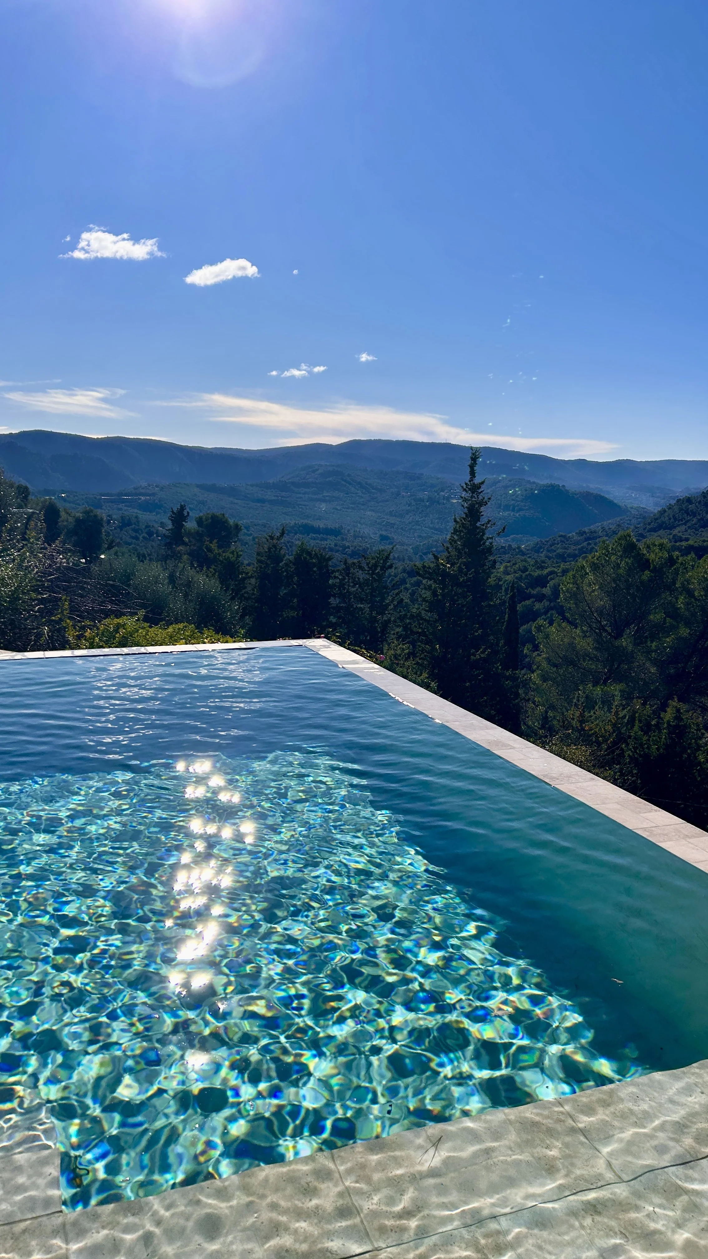 Piscine avec vue sur des montagnes et un ciel bleu.