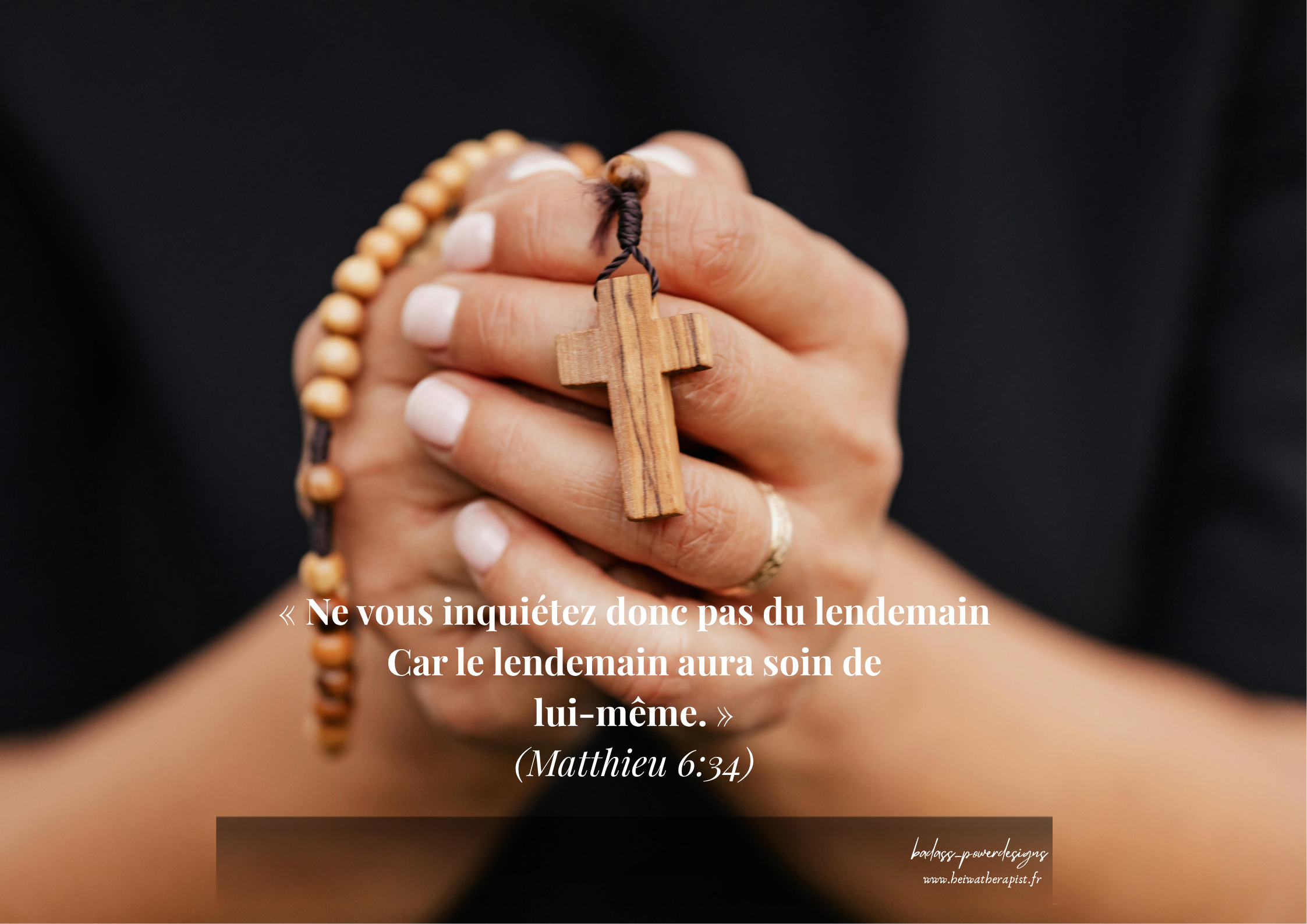 Photographie de mains jointes tenant un chapelet en bois avec une croix, sur un fond sombre. Texte en blanc : citation biblique de Matthieu 6:34 en français. Signature badass_powerdesigns et beiwatherapist.fr en bas.