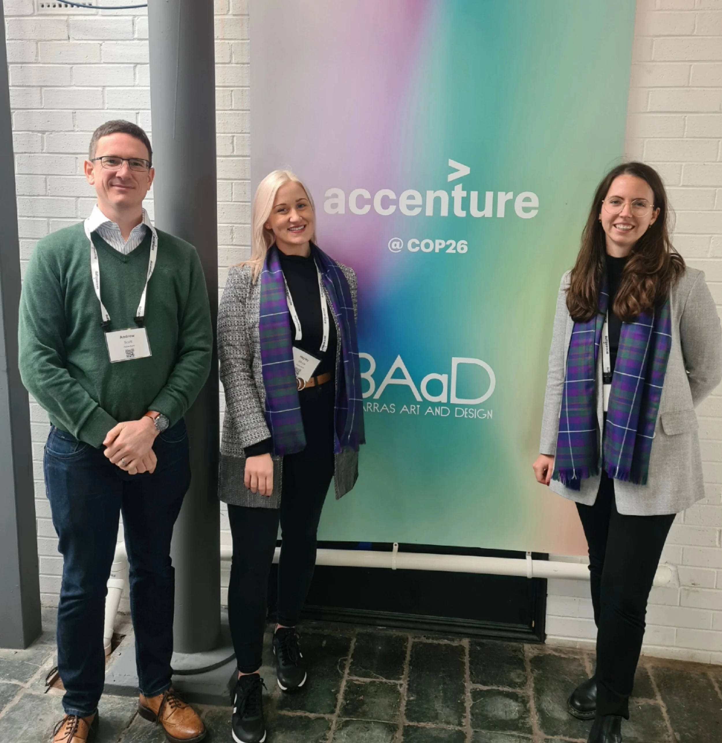Three professionals in from of a COP26 sign