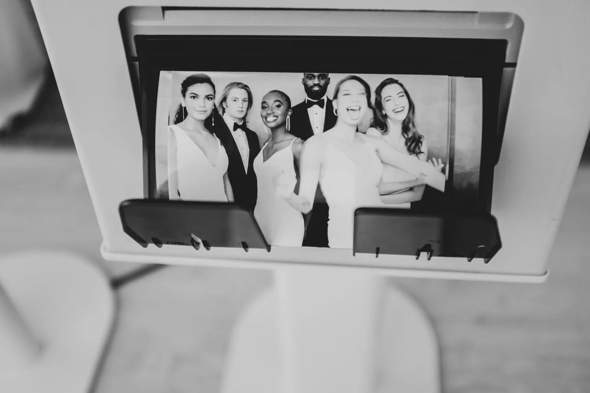 A black-and-white photo of six diverse people dressed in formal attire, standing together and smiling.