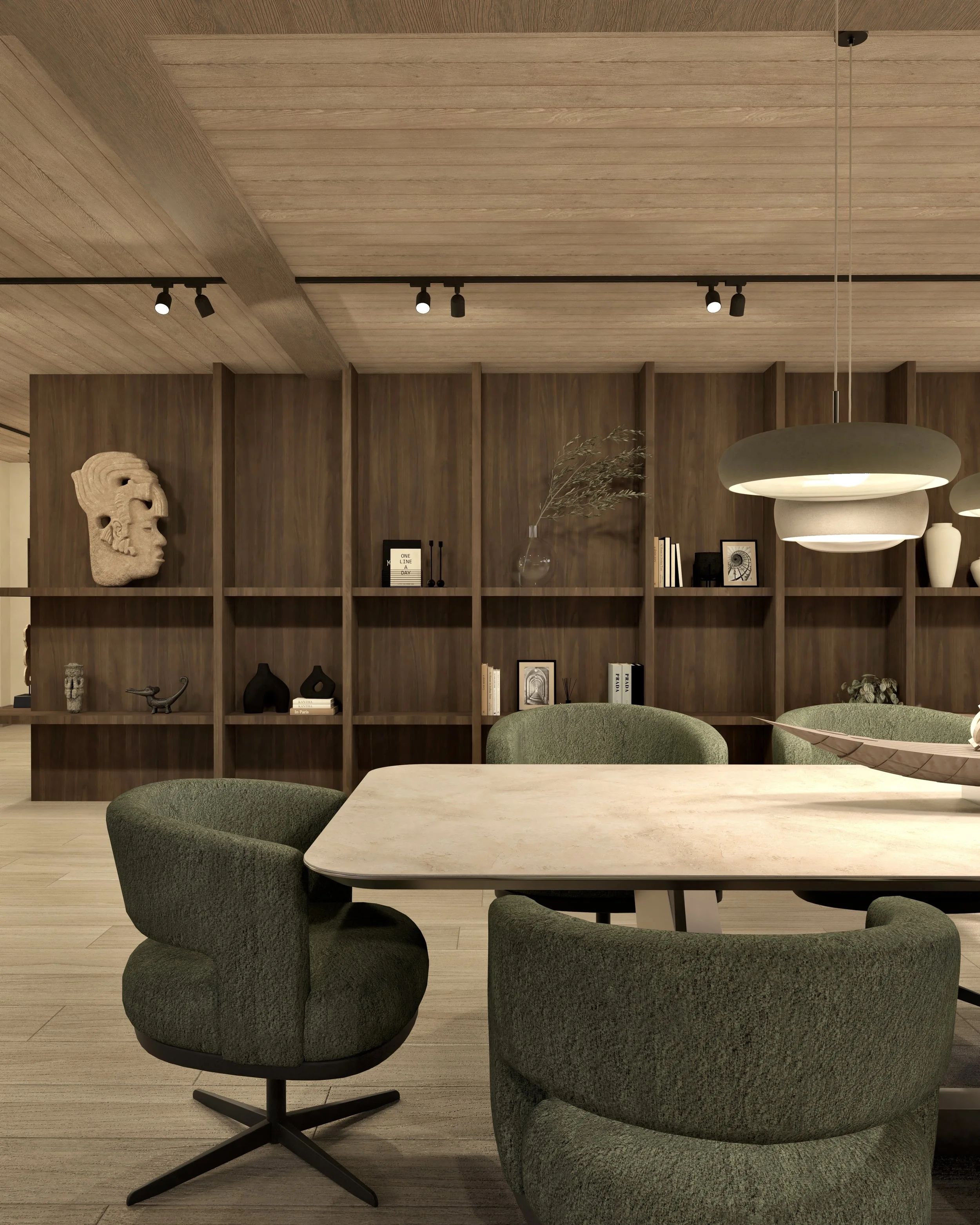 Een interieur met een houten wandrek, decoratieve voorwerpen, boekenkast, groene fauteuils en een marmeren tafel.