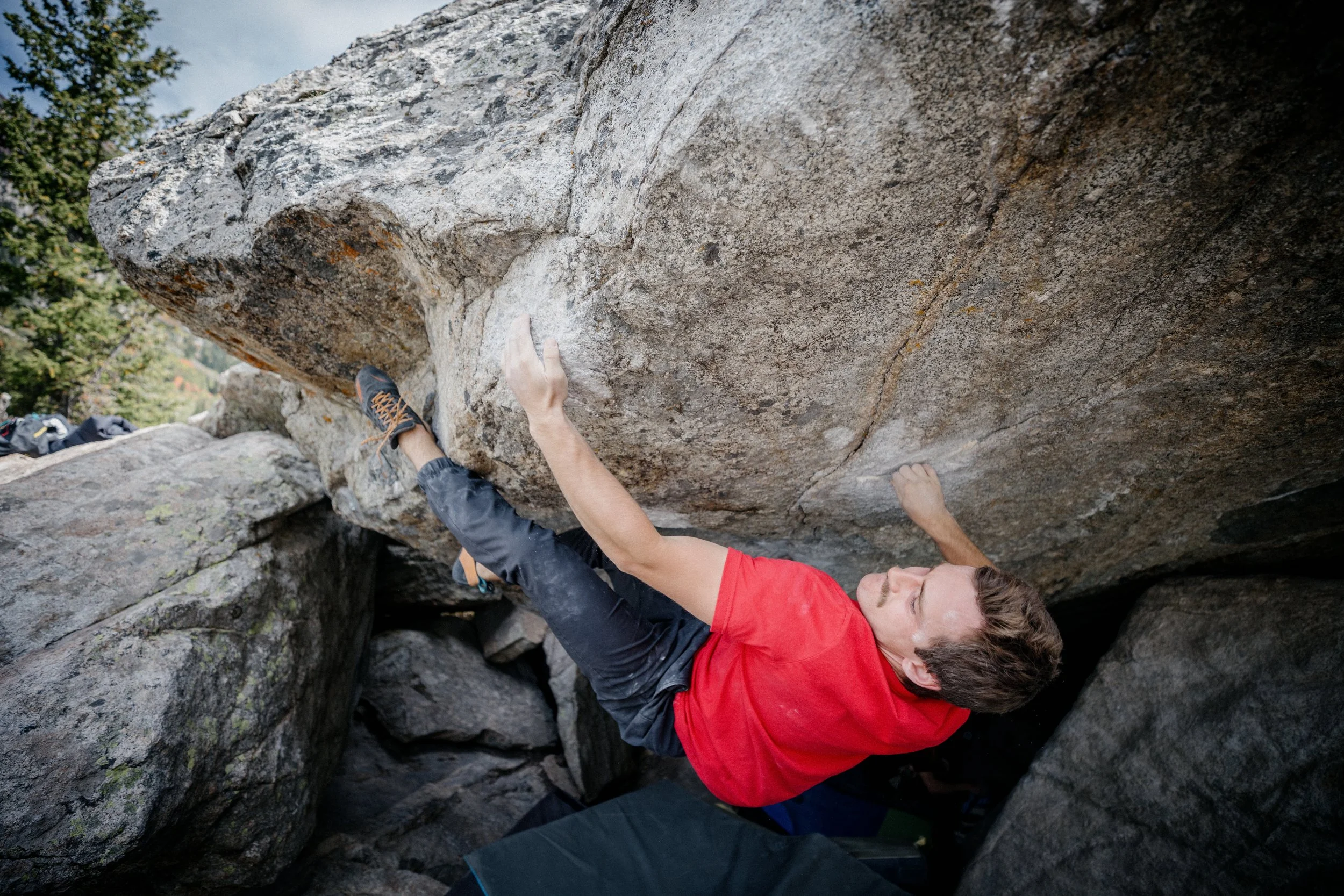 A person rock climbing outdoors on a large overhanging rock formation.