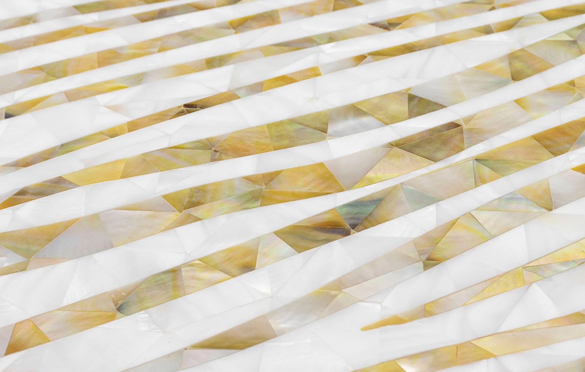 Close-up of a surface with a geometric pattern of white, yellow, and iridescent tiles arranged in a layered, wavy design.