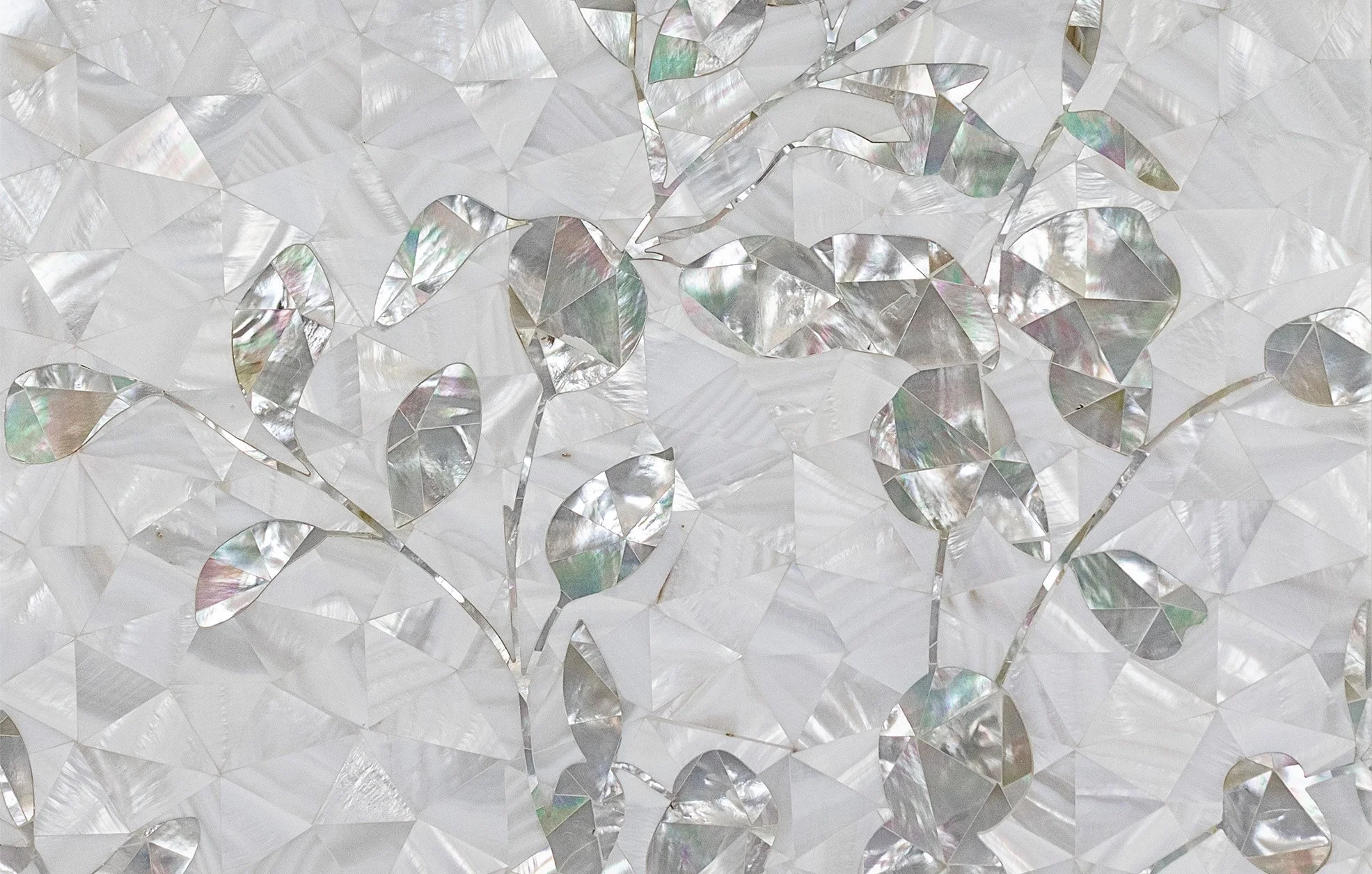 Elegant wallpaper with a pattern of iridescent leaves and branches on a reflective, geometric background.