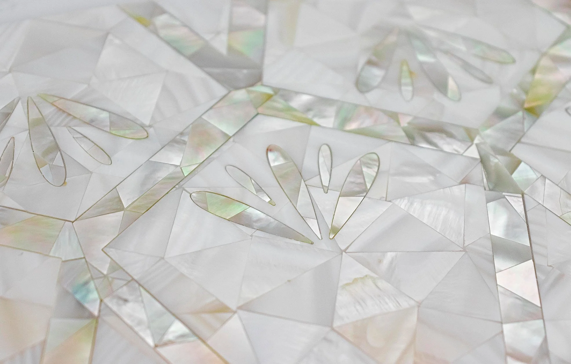 Close-up of iridescent, translucent overlay with cut-out leaf and floral shapes, possibly decorative or for art projects.