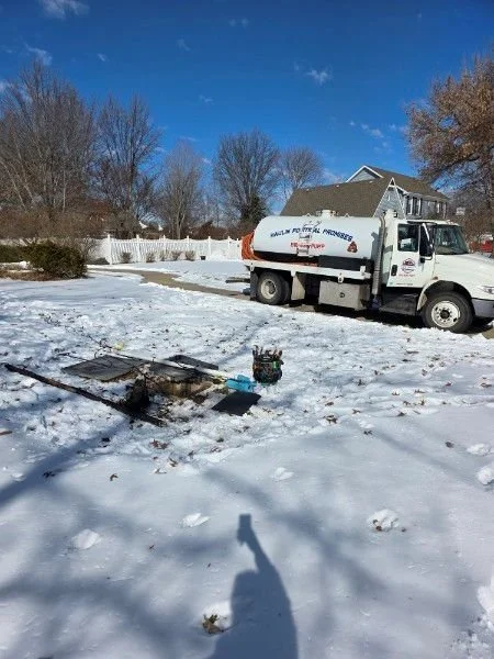 Septic pump truck at job site in the snow