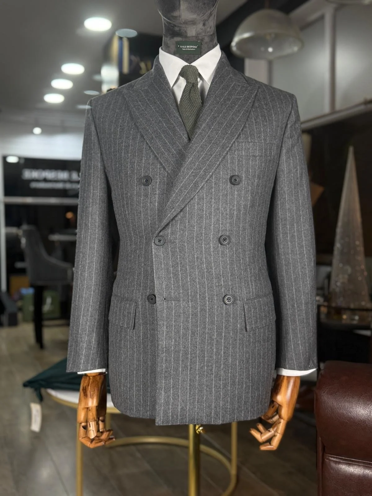 Brown chalk stripe flannel suit from Standeven Uxbridge flannel bunch full bespoke by kale bespoke on shop mannequin with a green silk knitted tie.