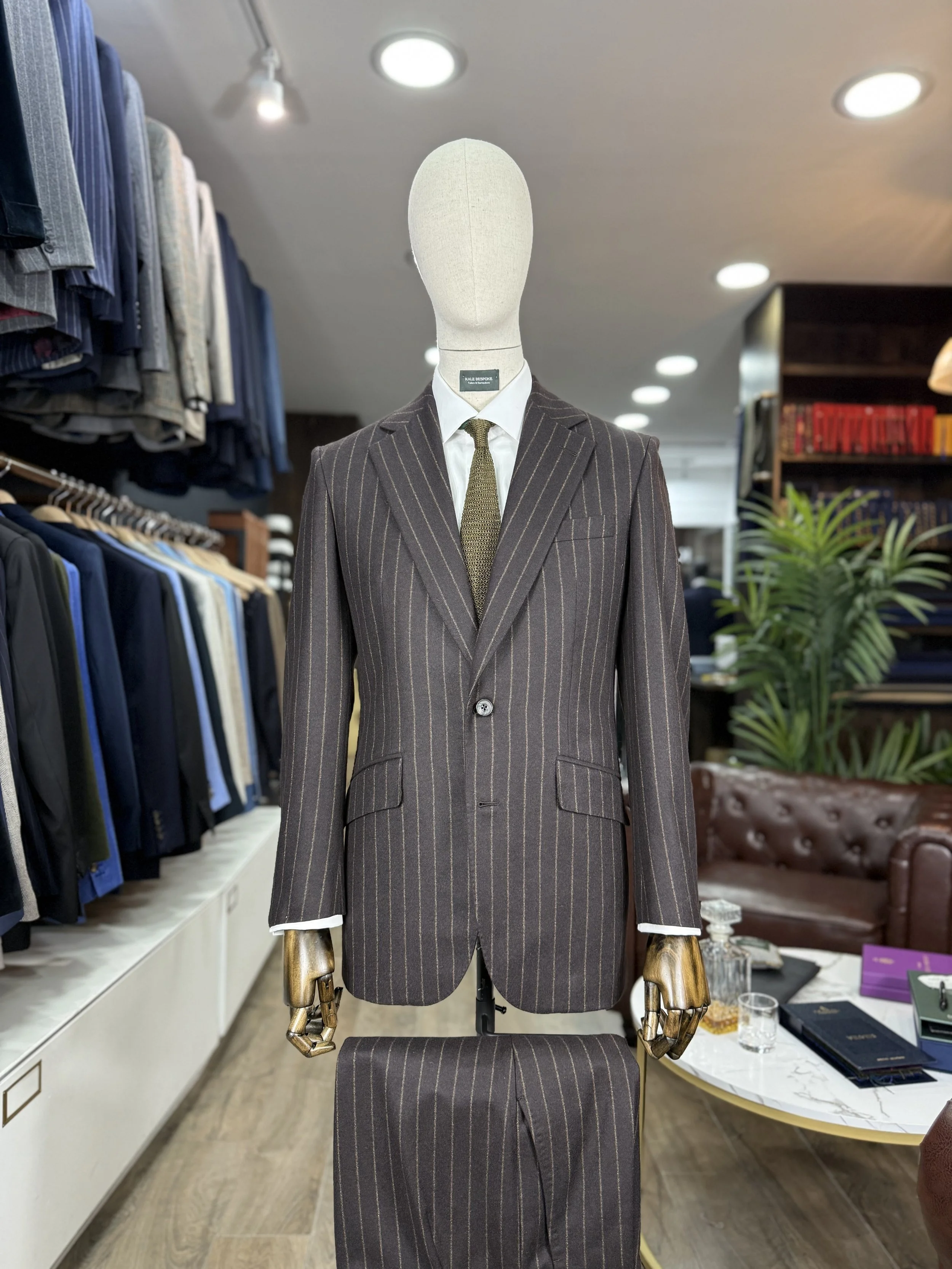 Brown flannel chalk stripe suit from standeven uxbridge flannel bunch 12oz.Two piece bespoke suit by Kale bespoke showcase on shop mannequin with green silk knitted tie.