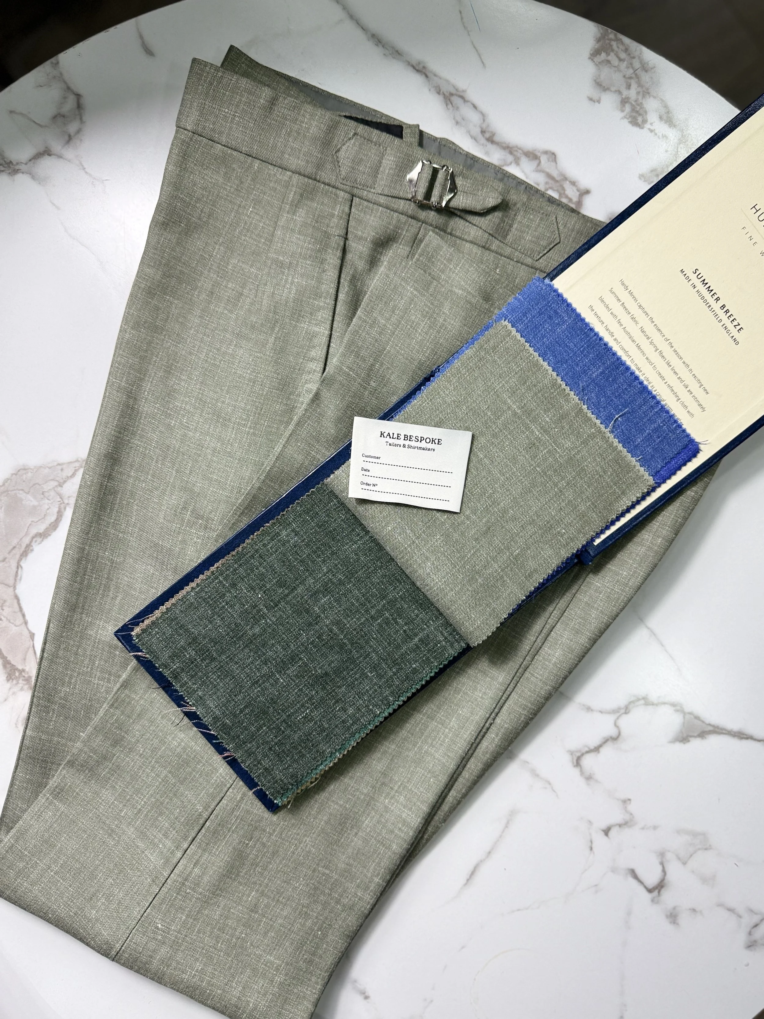 Handmade bespoke trousers in a refined pistachio green wool, silk, linen blend. Designed for warm weather tailoring, featuring a lightweight breathable texture, clean front and side adjusters.Crafted in London with a focus on comfort, elegance, and s