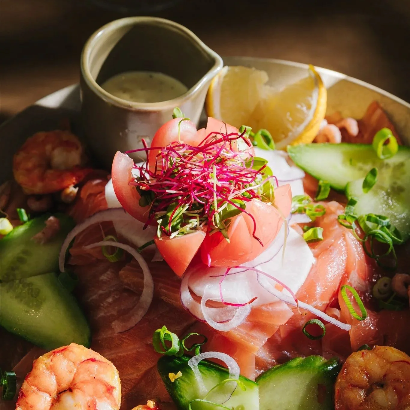 Close up van een salade met tomaat, zalm en scampi.