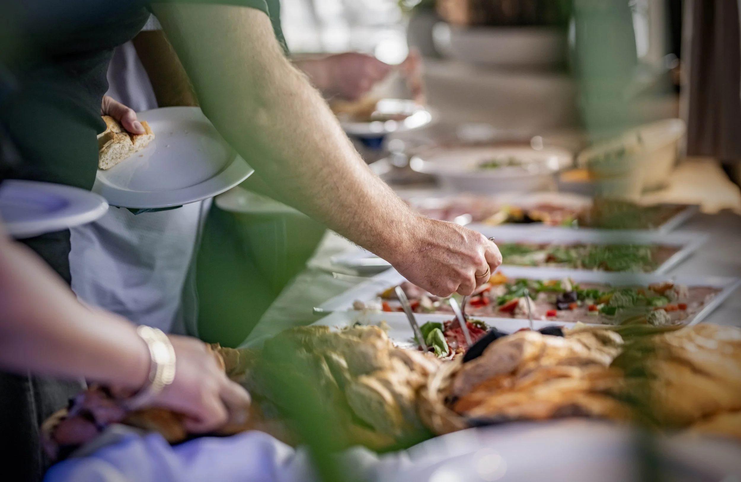 Mensen die zich bedienen bij een buffet met diverse gerechten.