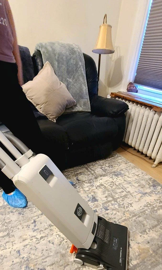 Hillshine Cleaning Duluth LLC owner vacuuming floor of living room in Duluth, MN.