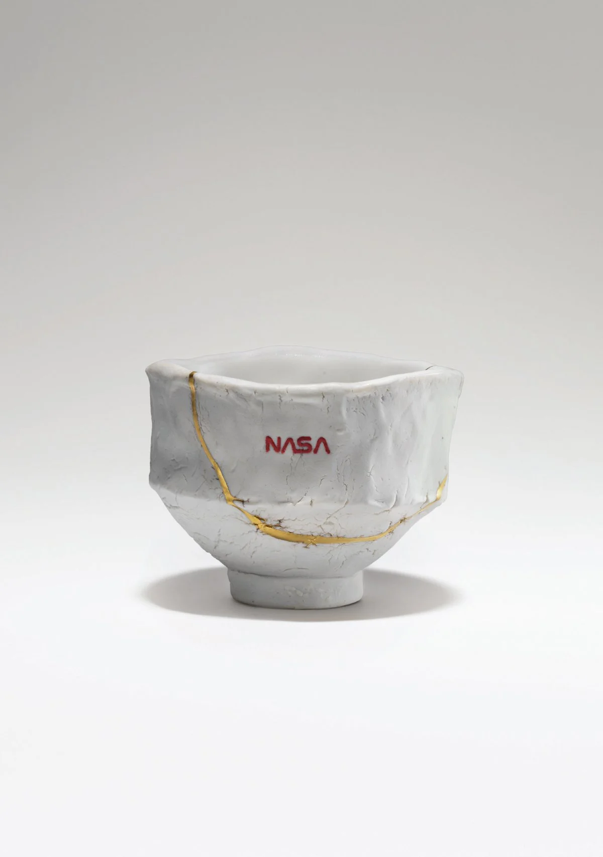  Tom Sachs,  Empyrean , 2019. Artwork © Tom Sachs (page 399) English porcelain, NASA red engobe inlay, and gold luster; 2 1/4 × 3 1/4 × 3 1/4 in. 