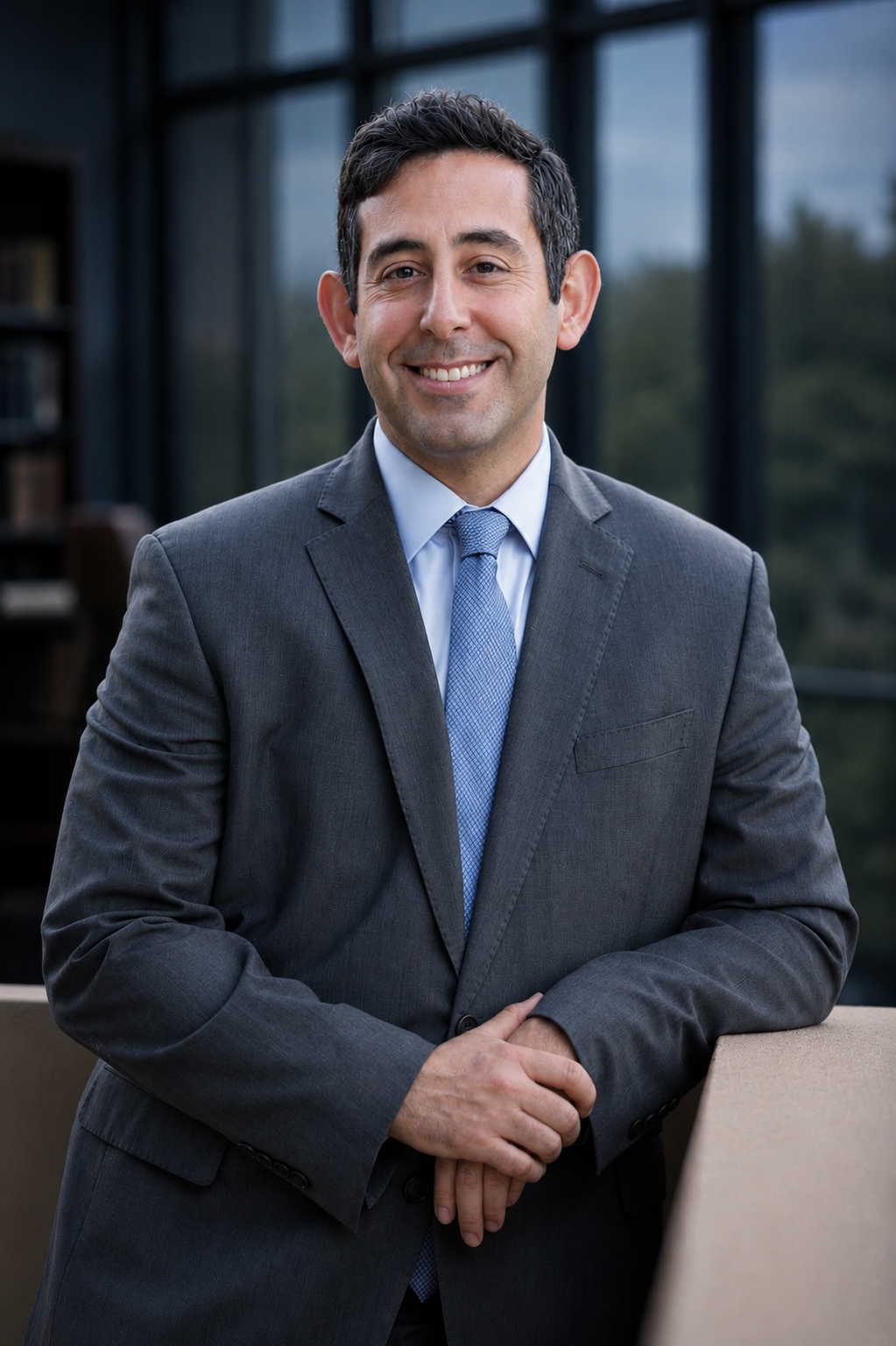 Professional man in a blue suit and tie outdoors with a blurred background.