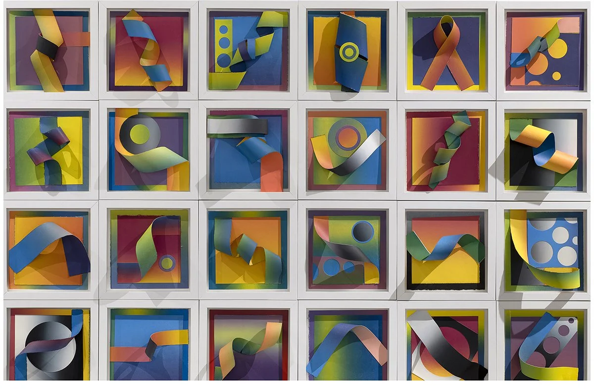 Colorful abstract art installation featuring 20 square frames with vibrant background colors and three-dimensional twisted paper or fabric shapes in various colors, arranged in a grid of five rows and four columns.