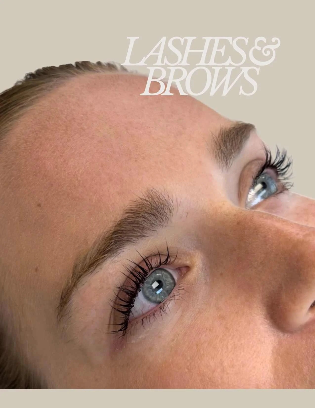 Close-up of a woman's face highlighting her eyebrows, eyelashes, and blue eyes with the text "LASHES & BROWS" in the top right corner.