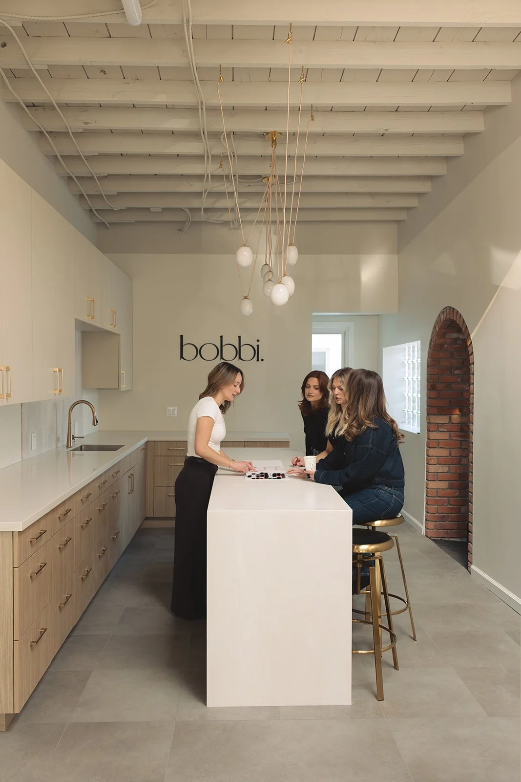 Stylists at Bobbi Grosse Pointe standing around a table learning about the latest in haircare techniques.