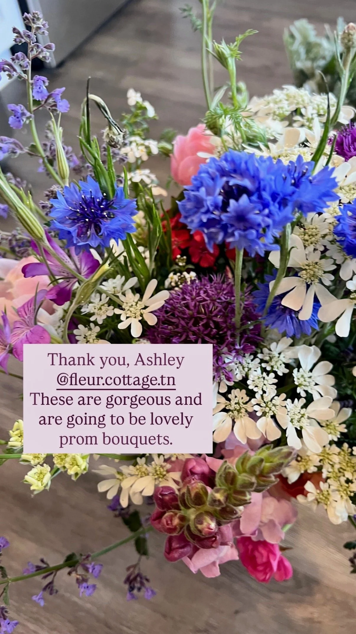 Customer Testimonial - they are happy with their prom flowers - featuring purple, pink, white, and blue fresh local flowers on a wooden surface.