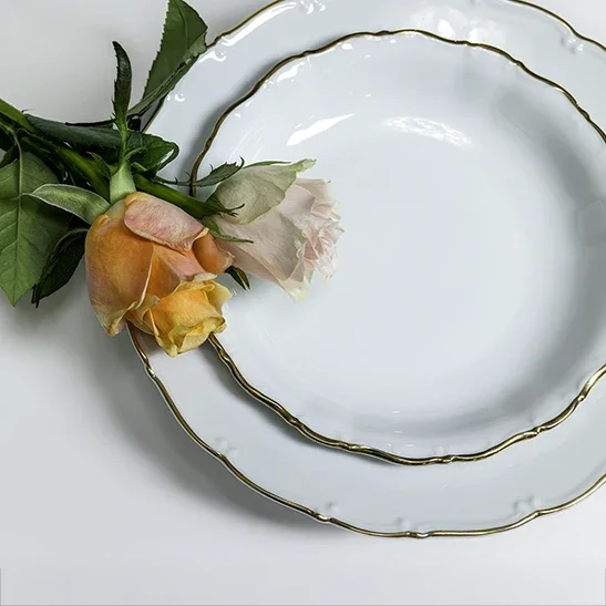 Valkoisia posliinisia pyöreitä tarjoilulautasia JuhlaToppilan vuokrattavissa astioissa.