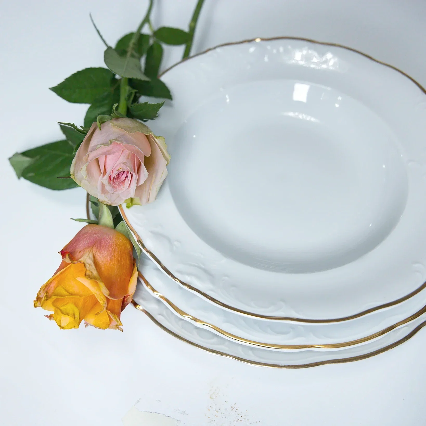 Valkoisia posliinisia keittolautasia JuhlaToppilan vuokrattavissa astioissa.