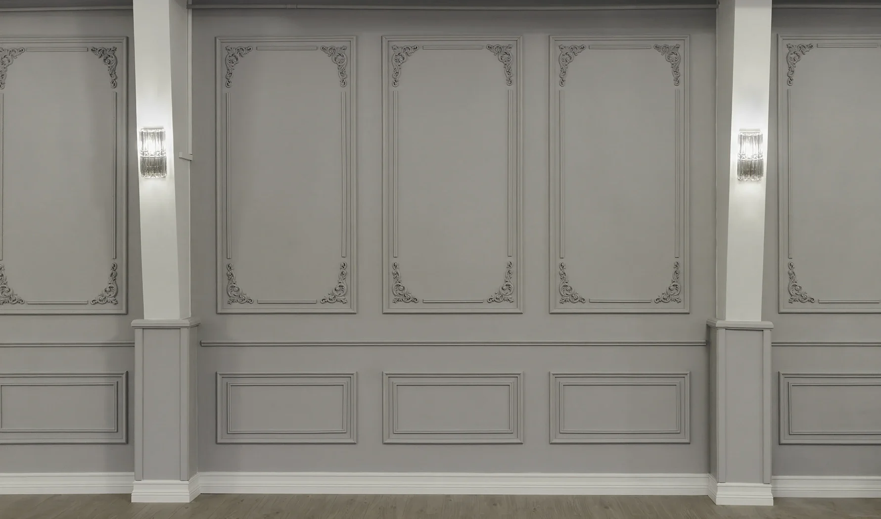 Vuokrattava uniikki juhlatila Oulussa, jonka vaaleassa salissa on koristeelliset seinälistoitukset ja kristalliset seinävalaisimet.