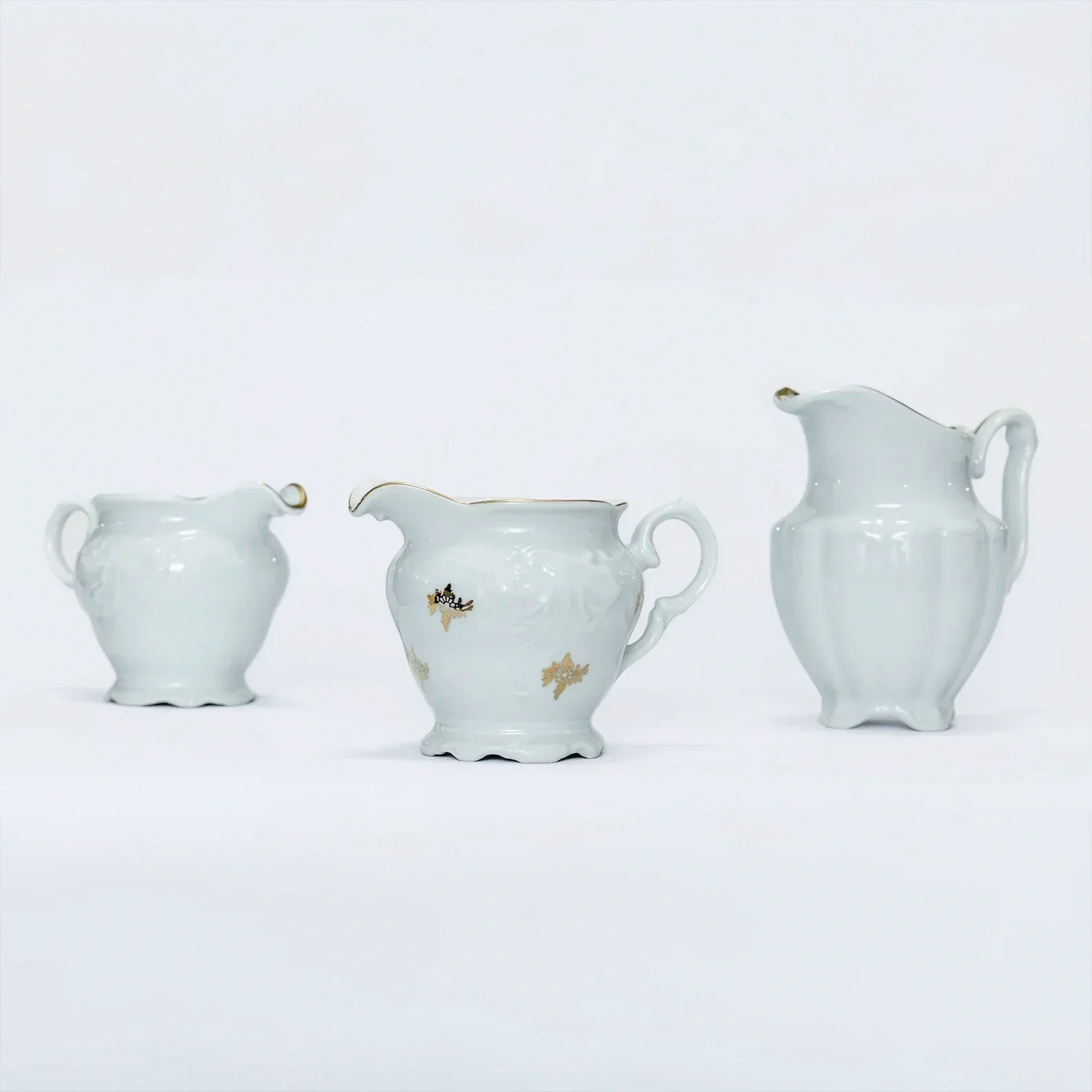 Valkoisia posliinisia kermakkoja JuhlaToppilan vuokrattavissa astioissa.