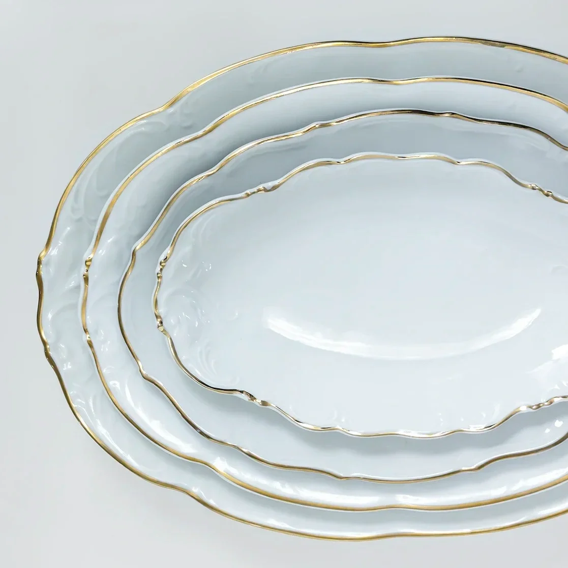 Valkoisia posliinisia ovaaleja tarjoiluastioita JuhlaToppilan vuokrattavissa astioissa.