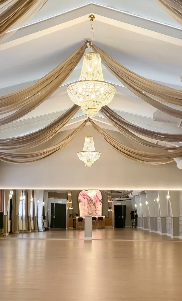Avara juhlasali Oulussa, jossa korkea katto, useat kristallikruunut ja vaaleat seinäpinnat luovat arvokkaan tunnelman.