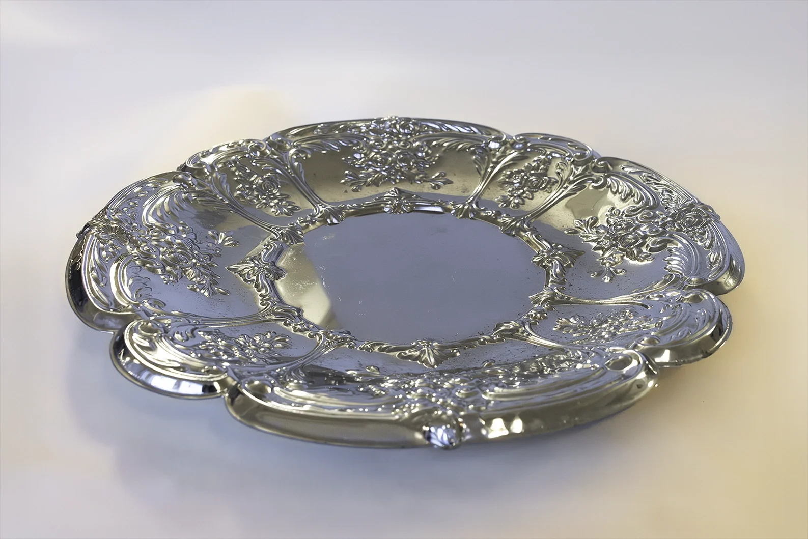 Koristeellinen pyöreä metallinen tarjotin JuhlaToppilan astiavuokrauksessa.