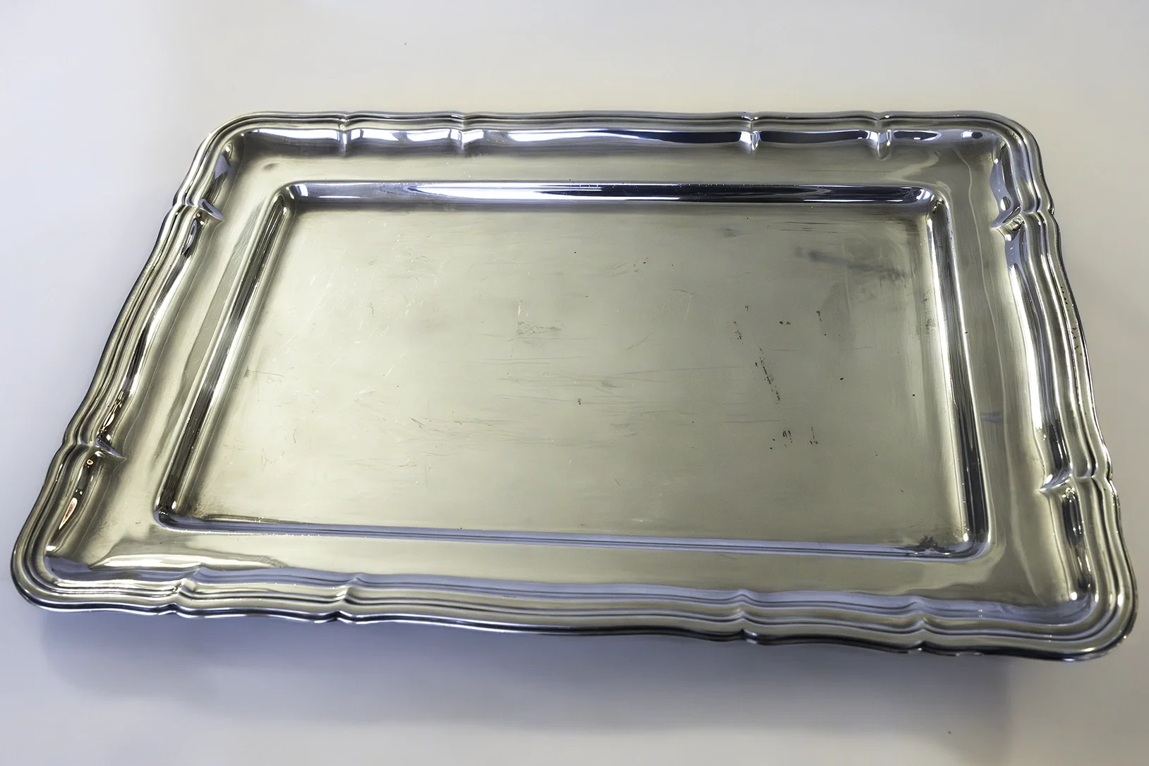 Kevyesti koristeltu metallinen tarjotin JuhlaToppilan astiavuokrauksessa.