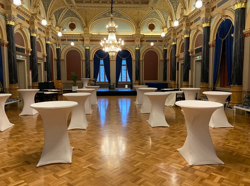 Sali, jossa on valkoisia vuokrapöytiä Oulussa