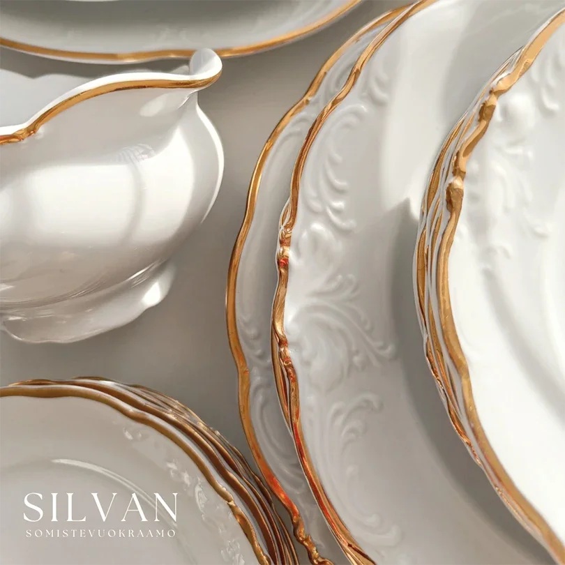 Posliinisia kultareunaisia vuokra-astioita.