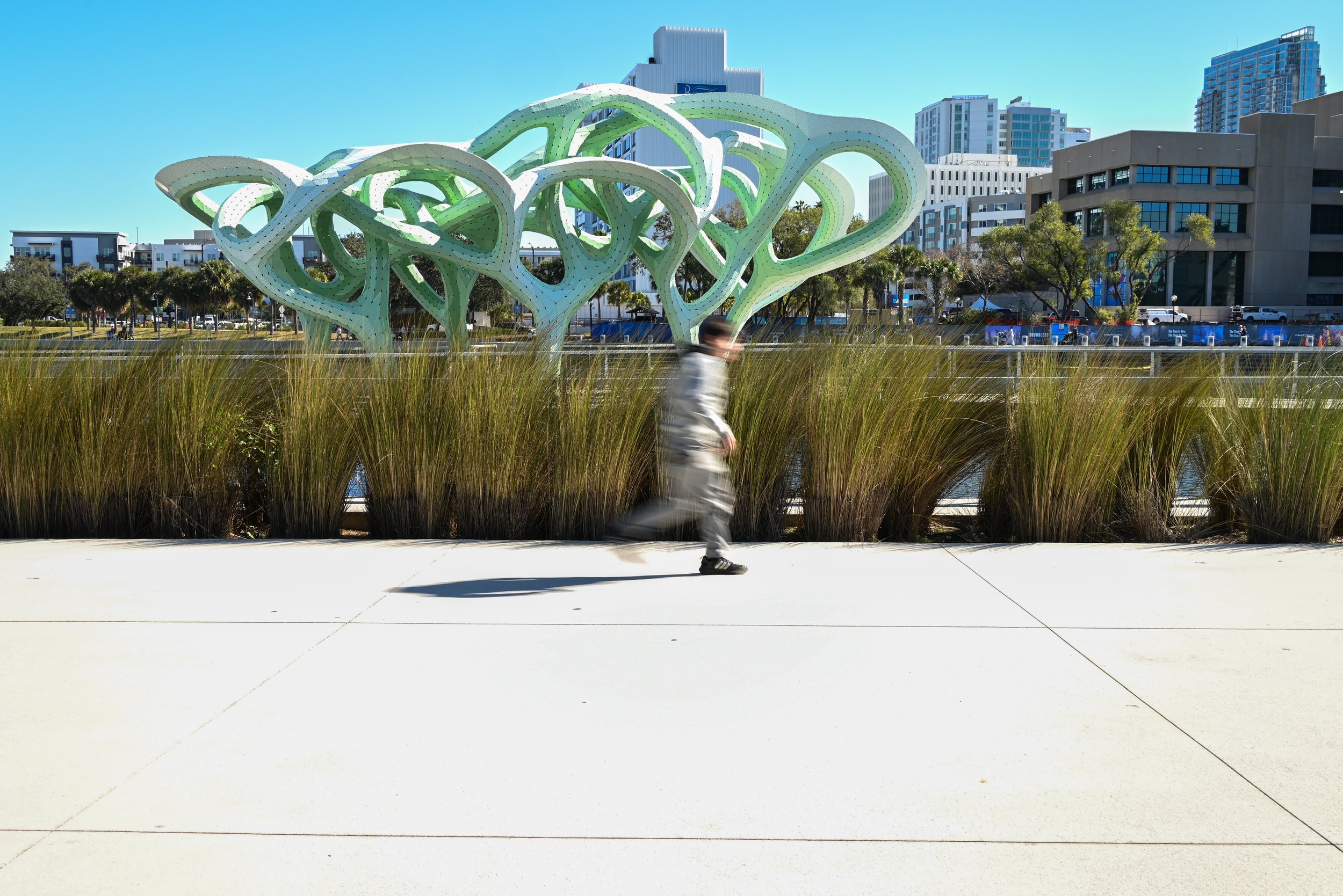 An adolescent running on the riverwalk, blurred, in downtown tampa