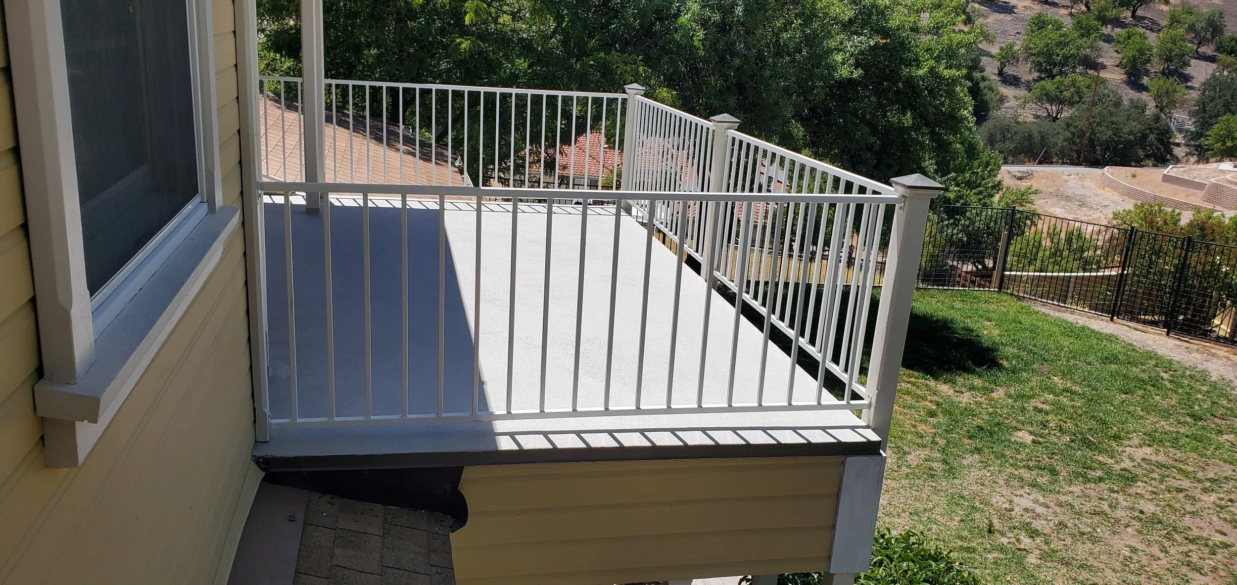 Scenic mountain landscape with snow-capped peaks in the background and rolling green hills in the foreground, featuring a modern building on the hills.