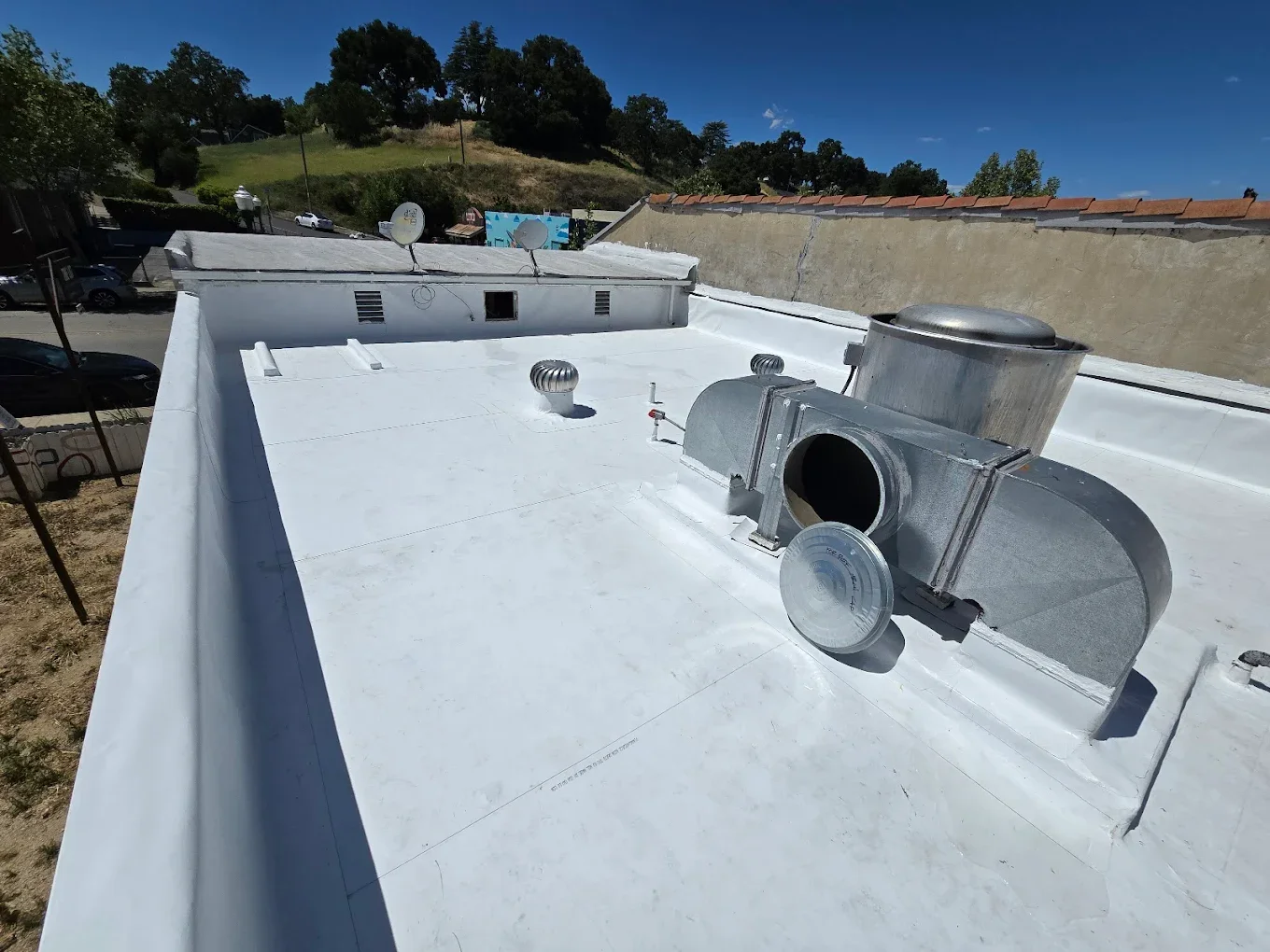 Mountain peak at sunset with an orange sky and dark silhouettes of surrounding mountains.