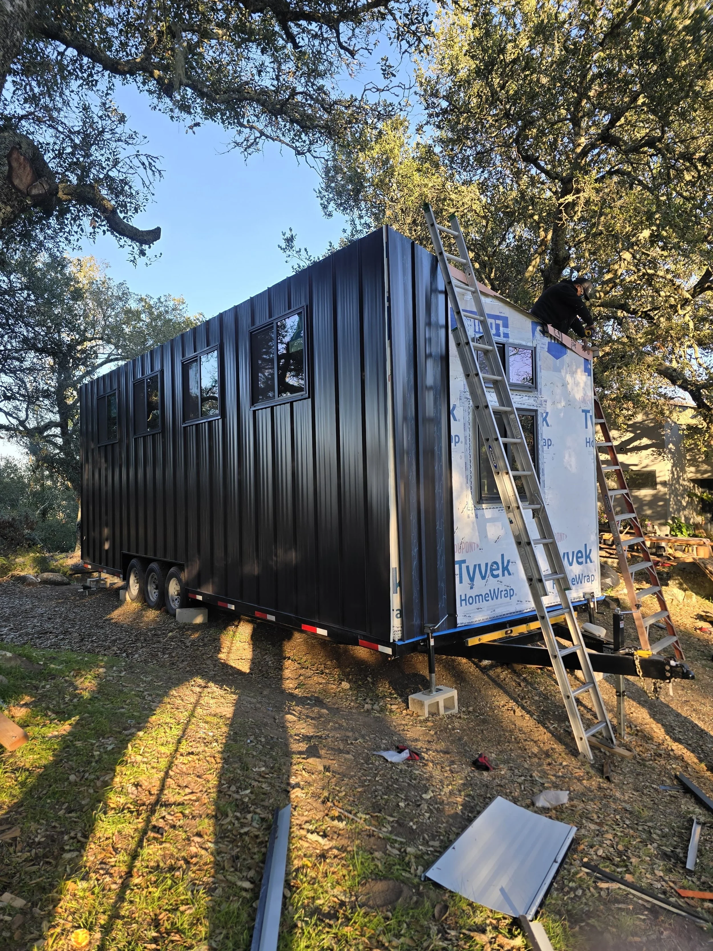 Landscape of a lake surrounded by rolling hills and mountains under a cloudy sky.